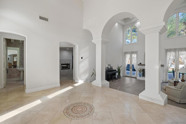 tiled foyer with a high ceiling and ornate columns