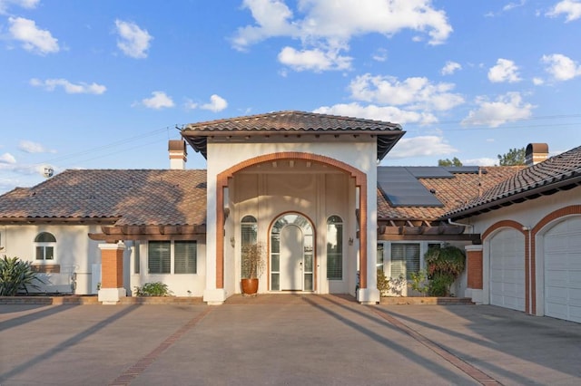 view of front of home featuring a garage and solar panels