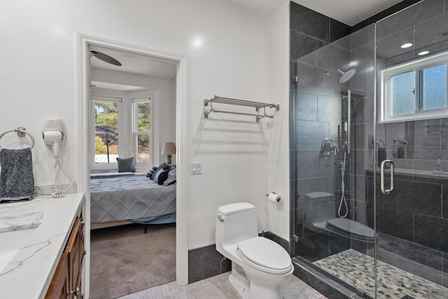 bathroom featuring toilet, vanity, and an enclosed shower