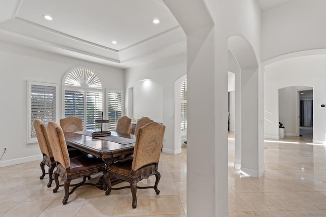 dining room with light tile patterned floors and a tray ceiling