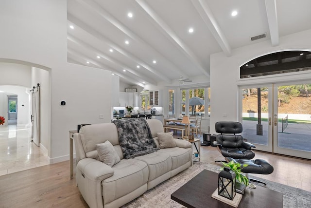 living room with french doors, beamed ceiling, and light hardwood / wood-style flooring