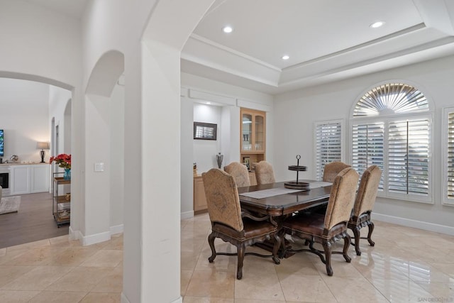 dining space featuring light tile patterned floors and a tray ceiling