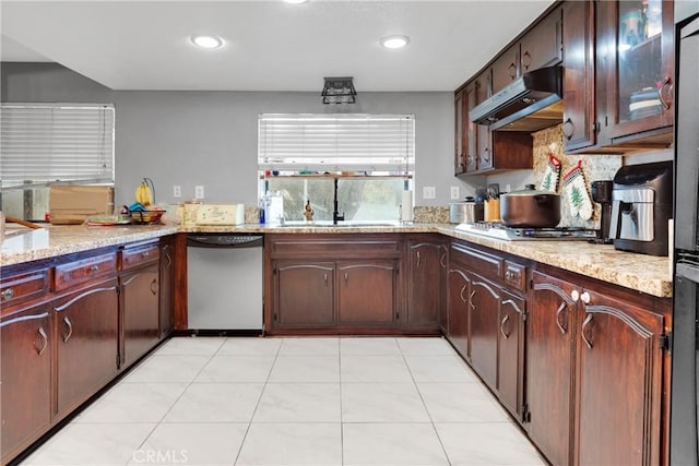 kitchen with appliances with stainless steel finishes, sink, backsplash, light tile patterned flooring, and light stone counters