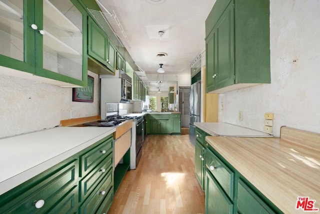 kitchen featuring light hardwood / wood-style flooring, green cabinetry, and stainless steel refrigerator