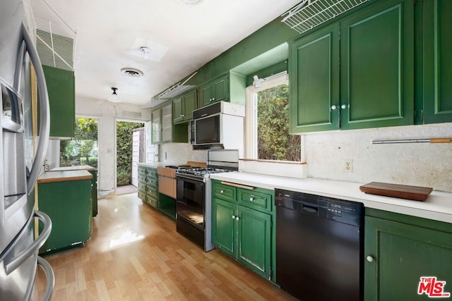 kitchen with dishwasher, light hardwood / wood-style flooring, stainless steel fridge, range with gas stovetop, and green cabinetry