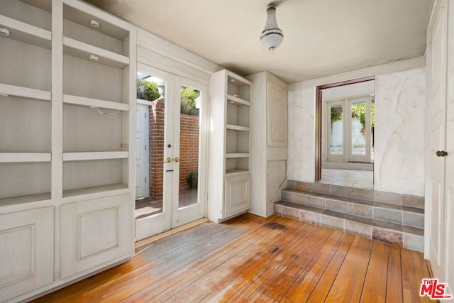 interior space with built in shelves, french doors, and a healthy amount of sunlight