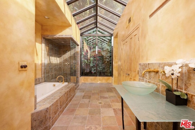 bathroom featuring a towering ceiling, sink, and plus walk in shower