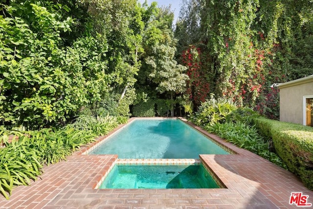 view of pool featuring an in ground hot tub