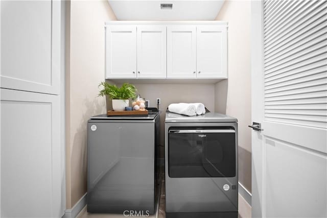 laundry room with independent washer and dryer and cabinets