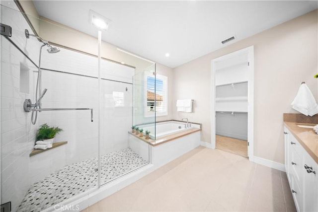 bathroom featuring separate shower and tub, vanity, and tile patterned flooring