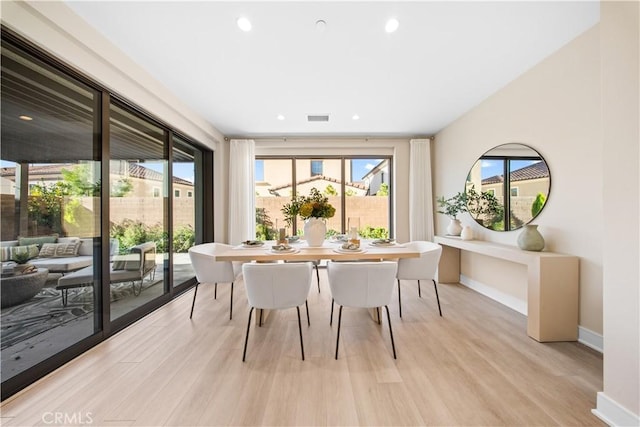 dining space featuring plenty of natural light and light hardwood / wood-style flooring