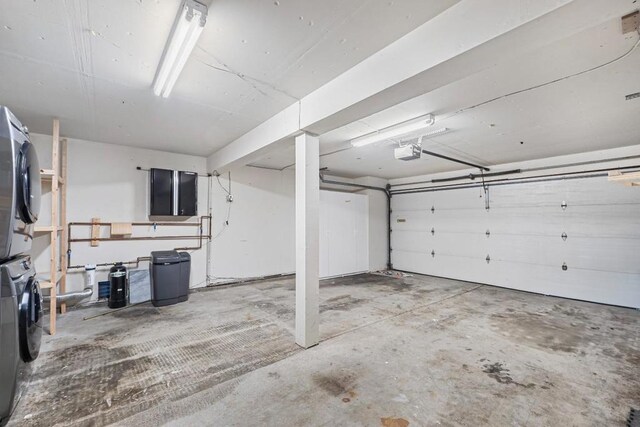 garage featuring a garage door opener and stacked washer / drying machine