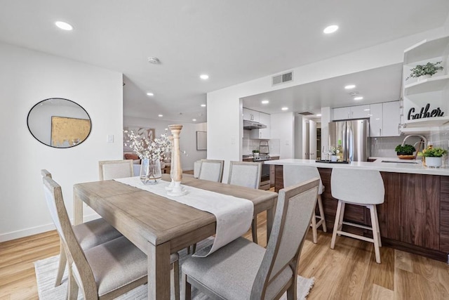 dining area featuring sink and light wood-type flooring