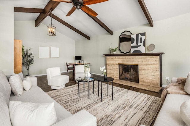 living room with ceiling fan with notable chandelier, hardwood / wood-style floors, and vaulted ceiling with beams