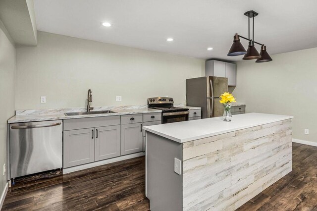 kitchen featuring gray cabinets, pendant lighting, sink, dark hardwood / wood-style flooring, and stainless steel appliances