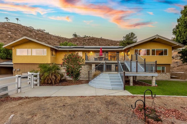 2846 Willow Glen Dr, El Cajon, CA 92019 - view of front of home with solar panels, stone siding, a gate, stucco siding, and stairway