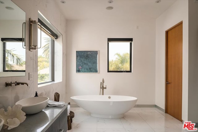 bathroom featuring a tub to relax in and vanity