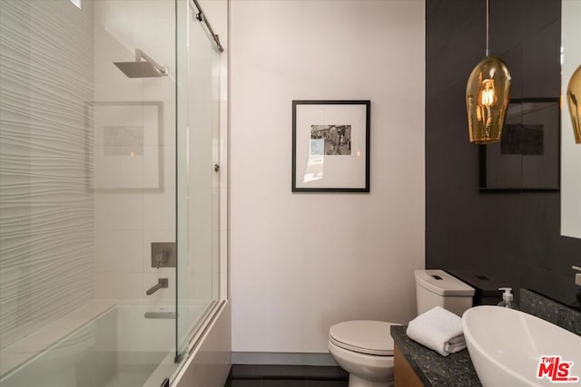 full bathroom with sink, toilet, and shower / bath combination with glass door