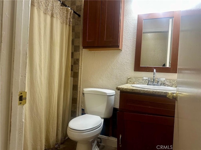 bathroom featuring vanity, toilet, and curtained shower