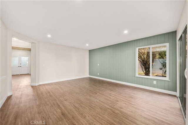 unfurnished room featuring wood finished floors, baseboards, and recessed lighting