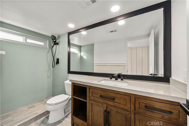 full bath with toilet, a shower, vanity, recessed lighting, and wood finished floors