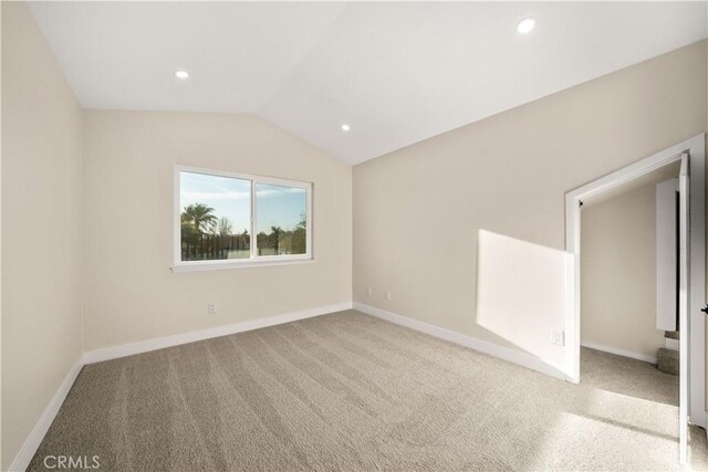carpeted spare room featuring vaulted ceiling, baseboards, and recessed lighting
