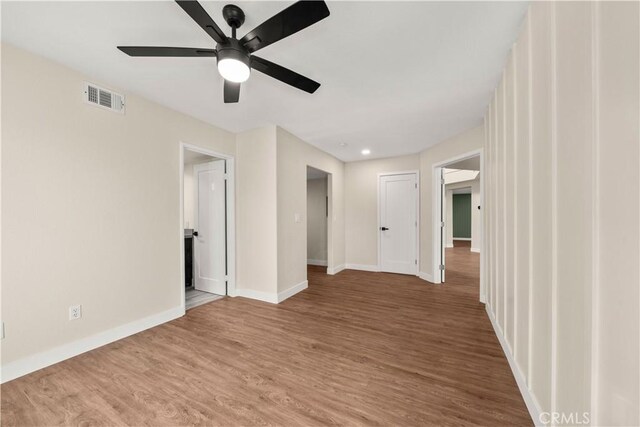 spare room with baseboards, ceiling fan, and wood finished floors