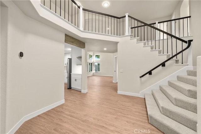 foyer entrance featuring a towering ceiling and hardwood / wood-style flooring