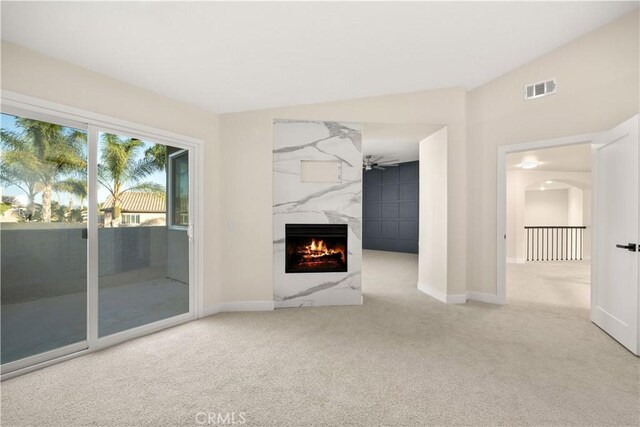 unfurnished living room featuring carpet, a premium fireplace, and baseboards