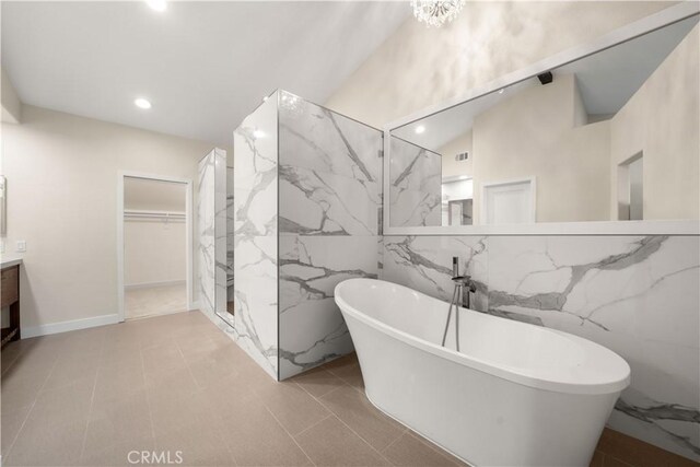 bathroom with vanity, a freestanding tub, tile walls, a marble finish shower, and recessed lighting