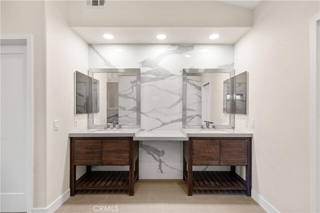 full bathroom featuring two vanities, baseboards, recessed lighting, and tile patterned flooring