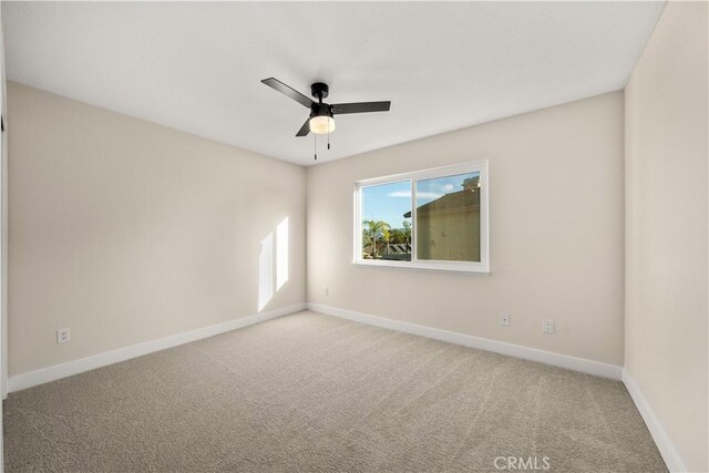 unfurnished room featuring ceiling fan, carpet floors, and baseboards