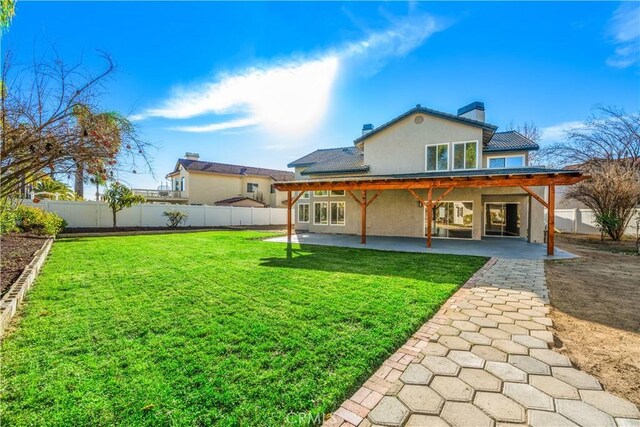 back of property with stucco siding, a patio area, and a chimney
