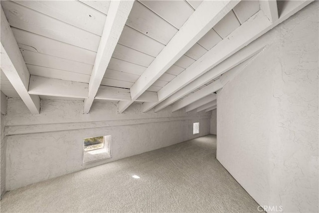 bonus room with plenty of natural light, beam ceiling, and carpet flooring