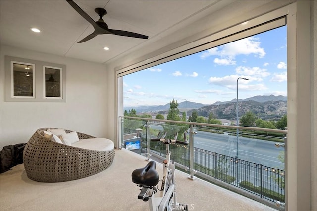 balcony featuring a mountain view and ceiling fan