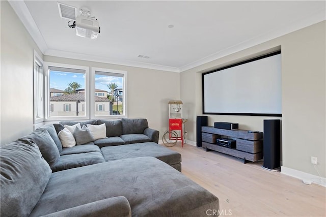 cinema room with ornamental molding and light hardwood / wood-style flooring