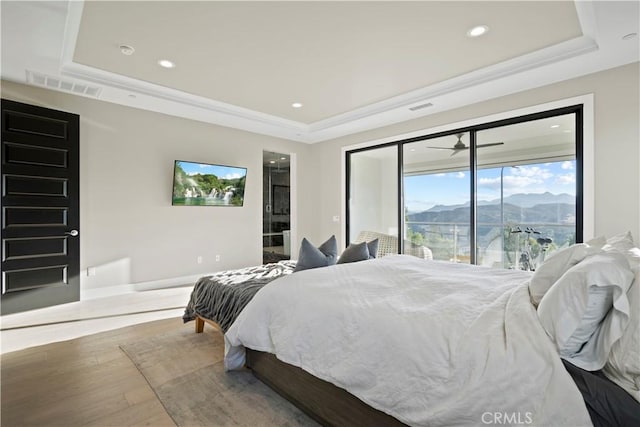 bedroom with hardwood / wood-style flooring and a raised ceiling