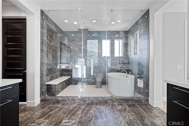 bathroom featuring tile walls, separate shower and tub, and vanity