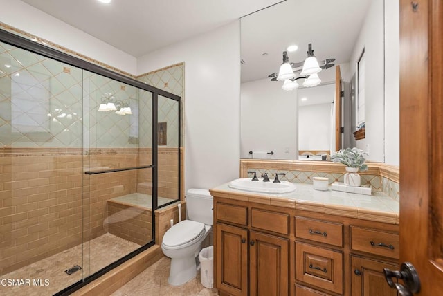 bathroom with toilet, vanity, an enclosed shower, and tile patterned flooring