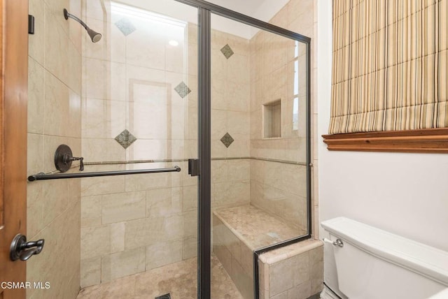 bathroom with an enclosed shower and toilet