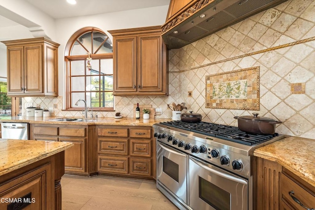 kitchen with premium range hood, sink, light wood-type flooring, light stone countertops, and appliances with stainless steel finishes