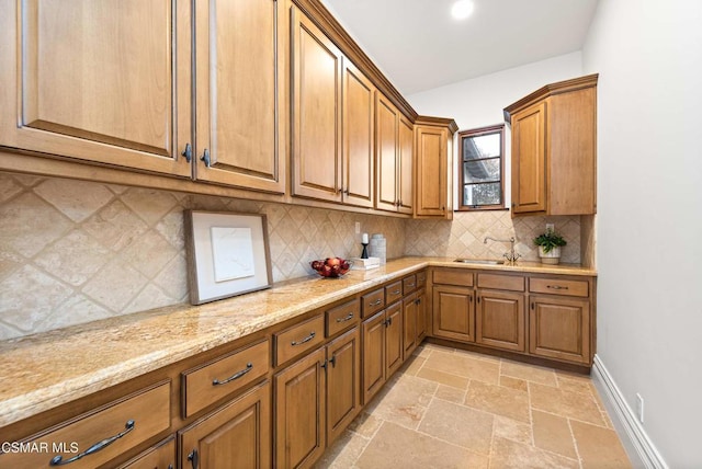 kitchen with backsplash, sink, and light stone counters