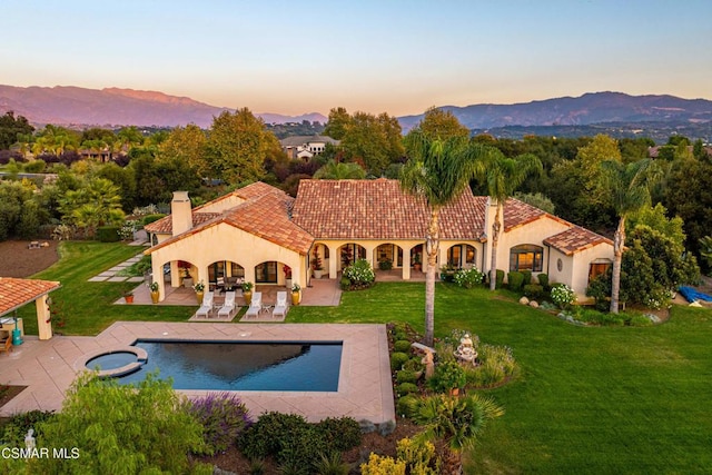 exterior space featuring a mountain view, a lawn, and a patio