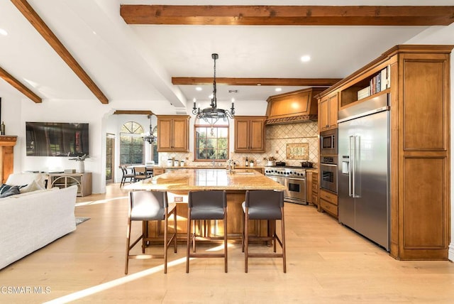 kitchen with tasteful backsplash, a kitchen breakfast bar, built in appliances, light stone counters, and beamed ceiling