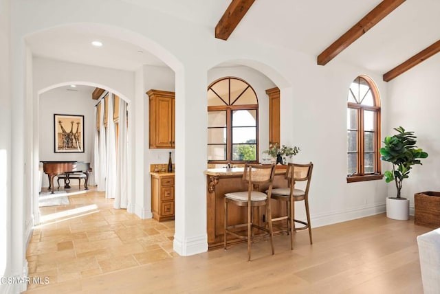 bar featuring a wealth of natural light and beamed ceiling