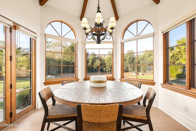 sunroom / solarium featuring lofted ceiling with beams and an inviting chandelier