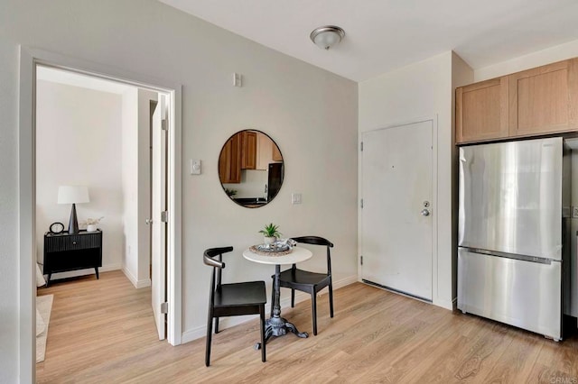 kitchen featuring light brown cabinetry, stainless steel fridge, and light hardwood / wood-style floors