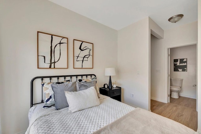 bedroom featuring ensuite bathroom and light wood-type flooring