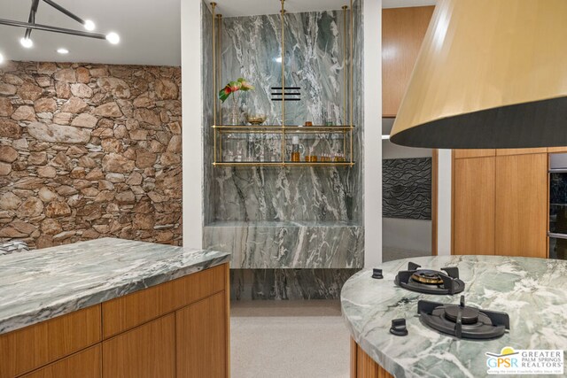 interior space with light stone counters and exhaust hood