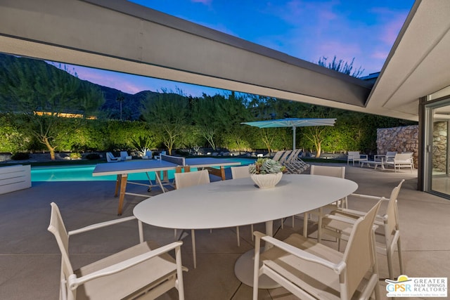 patio terrace at dusk featuring a mountain view